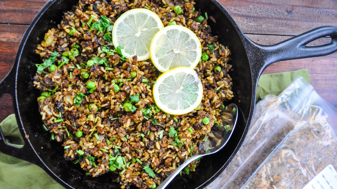 Skillet pan with tasty-looking pulao topped with lemon slices