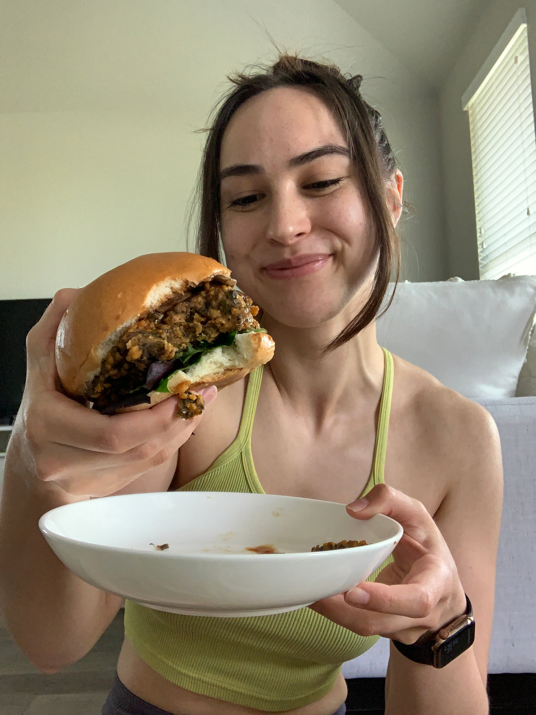 Brunette girl holding and enjoying the Kelp Burger